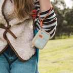 Girl holding Waffle Go screen-free kids phone on lanyard outdoors