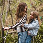 Two girls playing outdoors with Waffle Go screen-free phone with lanyard around wrist