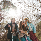 Three kids with bikes outdoors, girl holding Waffle Go screen-free phone, no apps no internet